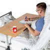 Patient im Pflegebett arbeitet am Brücke-Betttisch mit waagerechter Tischplatte